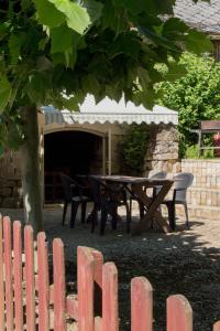 a picnic table and chairs in front of a building at Gite E'table Charlannes in Hautefage