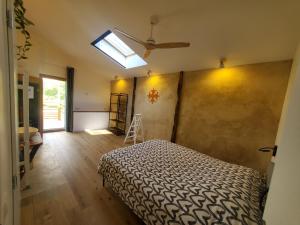 a bedroom with a bed and a skylight at Au Moulin du Miech in Salvagnac