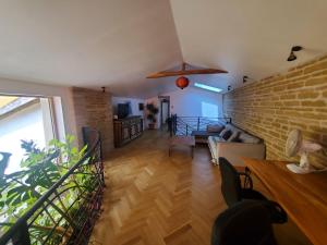 a living room with a couch and a brick wall at Au Moulin du Miech in Salvagnac