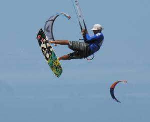 マラカジャウにあるLagoa dos Coqueirosのサーフボードに乗って空を飛ぶ男性