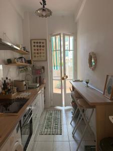 a kitchen with a sink and a table and a window at Dolce bilocale con terrazzo in Nice +4 photos