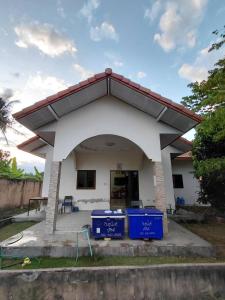 a house with two blue bins in front of it at ห้องว่างในบ้าน in Ban Bu Khi Lek