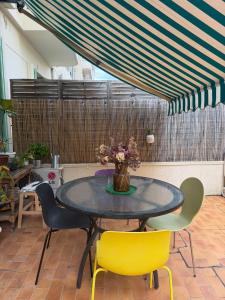 a table with chairs and a vase of flowers on it at Dolce bilocale con terrazzo in Nice