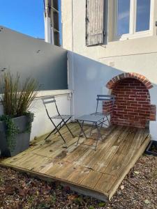 two chairs sitting on a deck next to a brick oven at Joli duplex rénové in Nevers