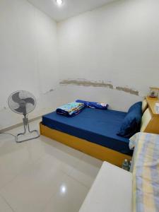 a bedroom with a blue bed and a fan at ห้องว่างในบ้าน in Ban Bu Khi Lek