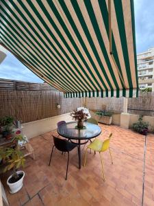 a patio with a table and chairs and a large umbrella at Dolce bilocale con terrazzo in Nice