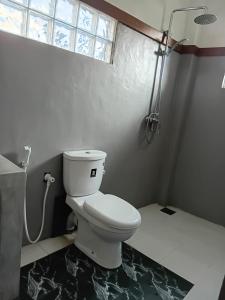 a white toilet in a bathroom with a window at Angels Negombo in Negombo +13 photos