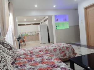 a room with a bed and a kitchen with a refrigerator at Cléopâtra 1 in Tefeschoun