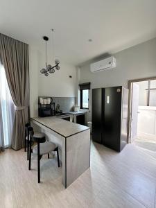 a kitchen with a table and a black refrigerator at 2 Bedroom Modern House in Ban Nong Chaeng