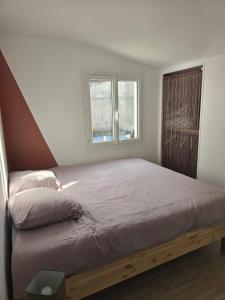a bed with a wooden frame in a bedroom at Maisonnette près de la plage in Aytré