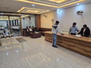 a man standing at a cash counter in a lobby at Hotel The Castle Inn in Varanasi
