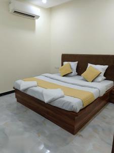 a wooden bed with yellow pillows in a room at Hotel The Castle Inn in Varanasi