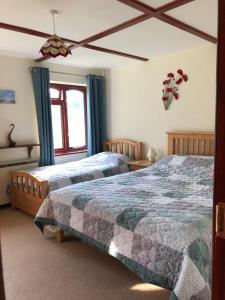 a bedroom with two beds and a window at Lower Thornton Farm in Exeter