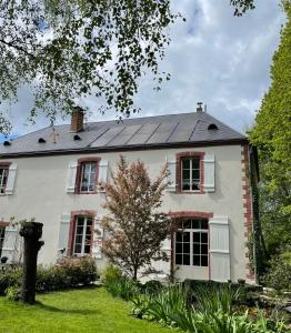 a white house with solar panels on the roof at Veï Lou Quéri in Moutier-Malcard