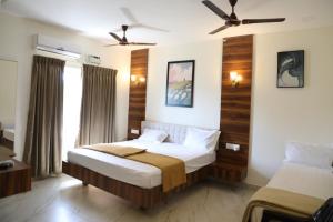 a bedroom with two beds and a ceiling fan at Hill Woods Yelagiri in Yelagiri