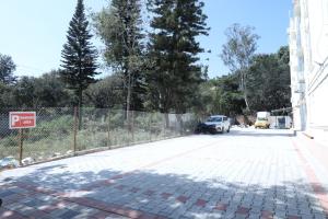 a parking lot with a fence and a car on it at Hill Woods Yelagiri in Yelagiri