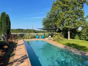 a swimming pool in a yard with a garden at Veï Lou Quéri in Moutier-Malcard