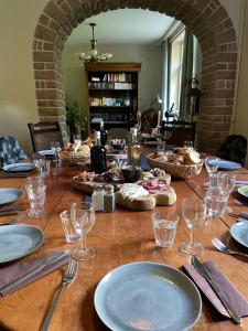 a long wooden table with plates and glasses on it at Veï Lou Quéri in Moutier-Malcard
