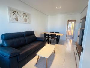 a living room with a couch and a table at Chalet La Mata in Torrevieja