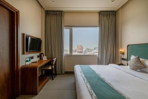 a hotel room with a bed and a desk and a window at Hotel Highway Prince Behror in Behror