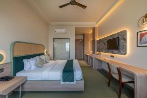 a bedroom with a bed and a desk and a tv at Hotel Highway Prince Behror in Behror