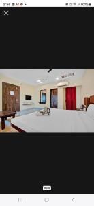 a living room with a large bed and a table at Hotel Krishna in Nagpur