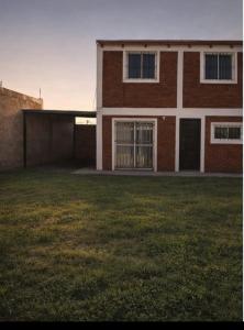 a brick building with a grass yard in front of it at Dúplex para 4 San Luis in Barranca Colorada