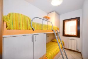 a bunk bed with a ladder in a room at Villaggio dei Fiori in Caorle +62 photos