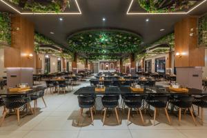 a restaurant with tables and chairs and plants on the ceilings at Hotel Highway Prince Behror in Behror +78 photos