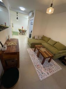 a living room with a green couch and a table at BLANK apartman u centru in Bjelovar