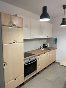 a kitchen with white cabinets and a stove top oven at BLANK apartman u centru in Bjelovar +13 photos