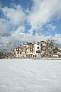 a large building in front of a snow covered field at Zeit.Glück Appartements in Radfeld