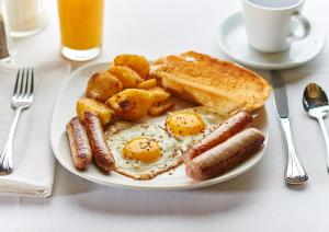 a plate of breakfast food with eggs potatoes and toast at Manchester Airport Stanley Hotel by Belvilla in Handforth