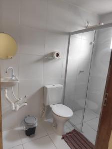 a white bathroom with a toilet and a shower at Pousada Oxente Carioca in João Pessoa +18 photos