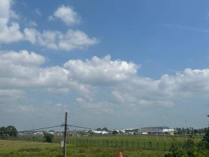a field with a fence and a sky with clouds at Andrew Transit Villa - Near Airport in Katunayaka