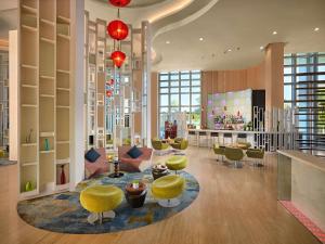 a lobby with yellow stools and a waiting room at Grand Mercure Danang - 10 minutes to Airport & 200m to Bach Dang Walking street in Danang