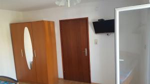 a room with a mirror and a wardrobe and a television at Apartmani kod Rade in Pakoštane