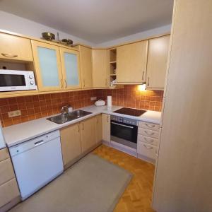 a small kitchen with white appliances and cabinets at Seekirchen Zentrum in Seekirchen am Wallersee