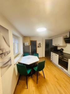 a kitchen with a table and chairs in a room at Ferienhäuser Radebeul "Apartment Altkötzschenbroda" in Radebeul