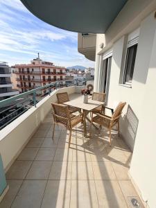 eine Terrasse mit Tisch und Stühlen auf einem Balkon in der Unterkunft Nastia in Chalkida