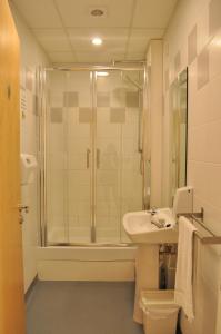 
a bathroom with a shower, toilet and sink at Garden Lane Backpackers in Dublin
