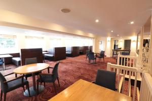 a restaurant with tables and chairs and tables and chairs at Manchester Airport Stanley Hotel by Belvilla in Handforth
