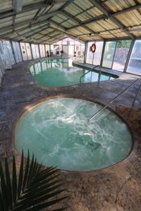 uma grande piscina de água verde num edifício em Crown Point Resort, by VRI Americas em Ruidoso
