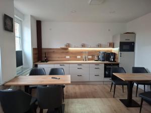 a kitchen with wooden tables and chairs in a room at Pension zum Kanal in Burg bei Magdeburg