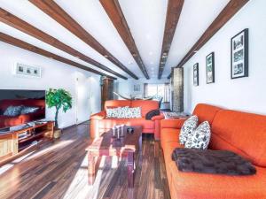 a living room with orange couches and a table at Inseldomizil - Melina in Malchow
