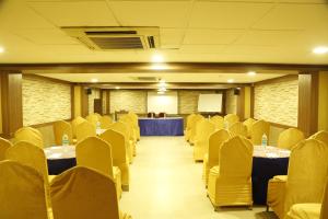 a conference room with tables and chairs and a podium at HOTEL GRAND PLAZzA in Coimbatore
