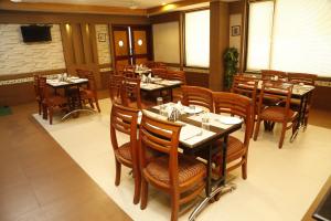 a dining room with tables and chairs in a restaurant at HOTEL GRAND PLAZzA in Coimbatore