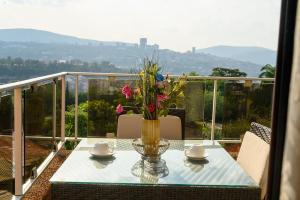 a vase with flowers on a table on a balcony at Residency by LMR in Kigali