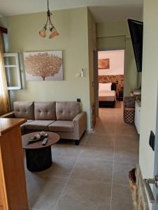 a living room with a couch and a table at Litsa's House Platanias in Agia Paraskevi