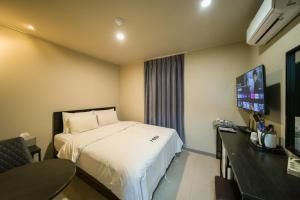 a hotel room with a bed and a flat screen tv at Hotel Remi in Seoul
